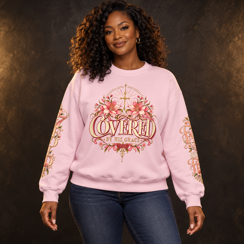 Black woman wearing the light pink 7Fold COVERED by His Grace floral crewneck, showing the front and sleeve designs