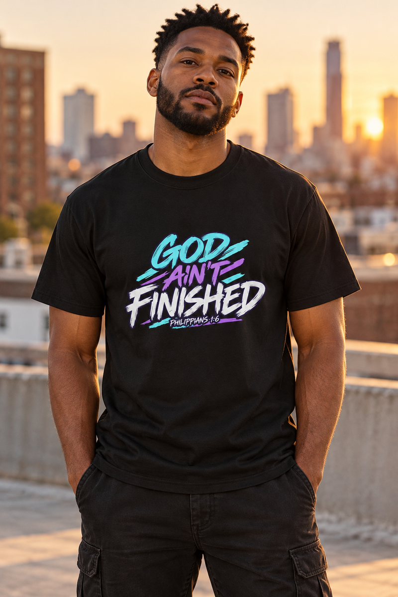 Black model wearing the 7Fold god aint finished shirt, front print visible in warm urban rooftop setting