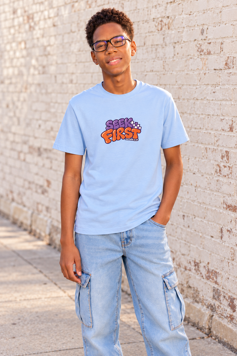 Child standing in a light blue Seek First 7Fold tee